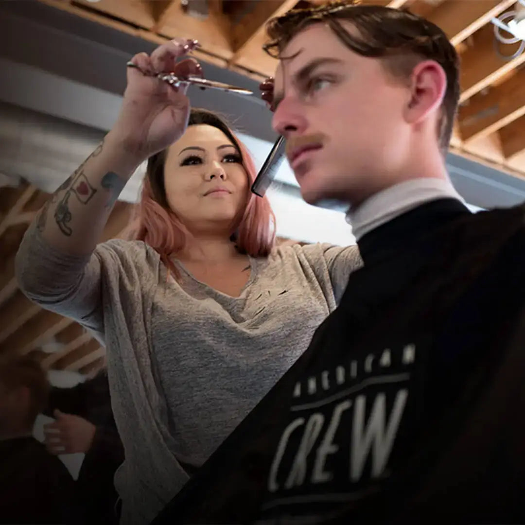 Stylist Cutting Guy's Hair for Men's Grooming Day by American Crew